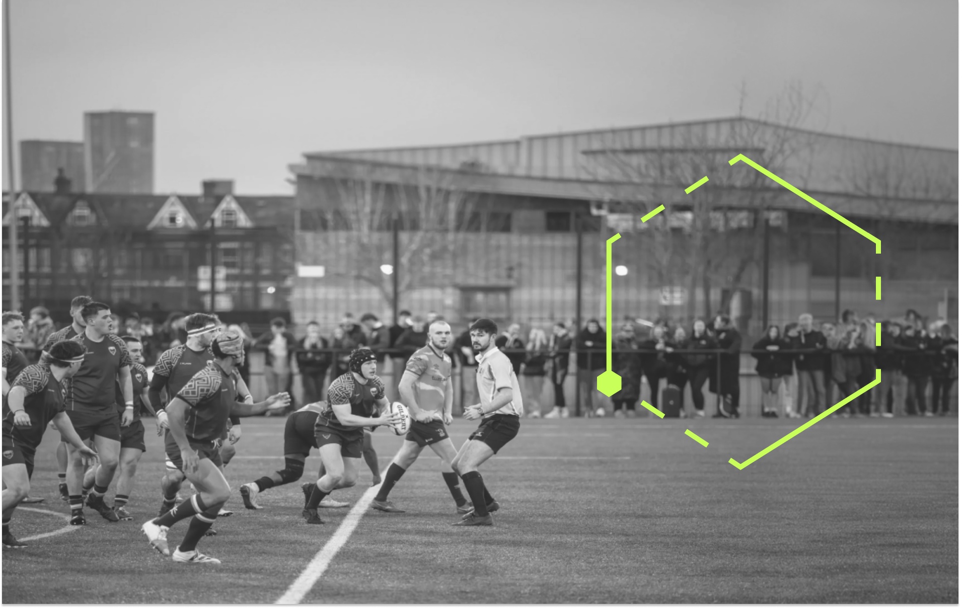 Rugby players running with the ball watched by an audience